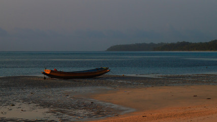 A boat lies beached at dawn in the Andaman and Nicobar Islands of India.