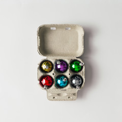 Christmas baubles decoration in egg carton box. New Year concept. Flat lay.