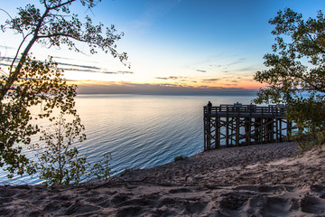 Sleeping Bear Dunes National Lakeshore, Large wooden overlook at sunset with silhouette of tourist...