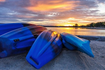 Summer Lake Sunrise Background. Kayaks line the lakeshore with vibrant and beautiful sunrise colors in the background. Grand Traverse Bay in Traverse City, Michigan, USA.