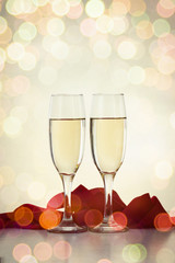 Two glasses with champagne and a red ribbon. Bokeh