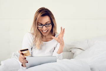 Gl&uuml;ckliche Frau macht online shopping mit ihrer Kreditkarte