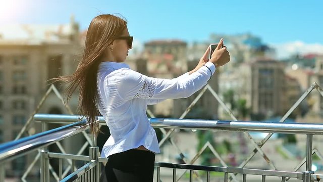 Woman records videos on smartphone. Businesswoman makes photos or records videos on his mobile phone. Beautiful girl with red cell phone