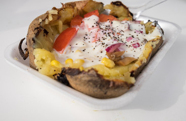 Baked potato with mushrooms, vegetables, cheese and cream sauce