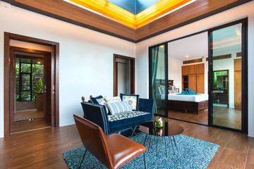 Luxury interior design in living room of pool villas. Airy and bright space with high raised ceiling and wooden dining table