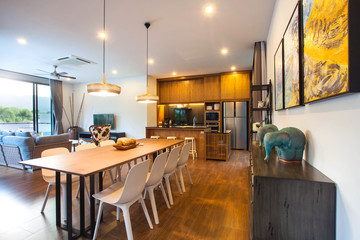 Luxury interior design in living room of pool villas. Airy and bright space with high raised ceiling and wooden dining table