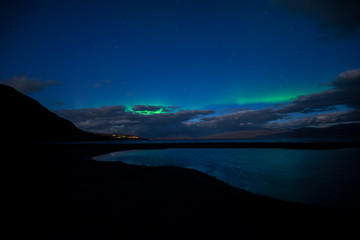 Fototapeta premium Northern lights background dancing over lake in Abisko national park in Sweden