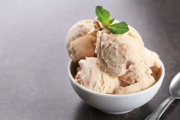 Delicious caramel ice cream in bowl on table