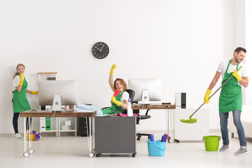Team of young cleaning service professionals at work in office