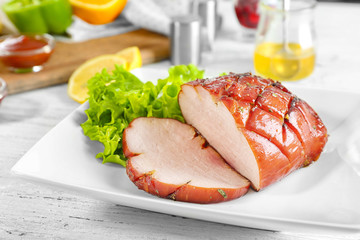 Plate with traditional honey baked ham on table