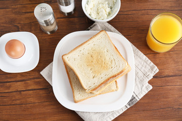 Composition with toasts, cheese and boiled egg on wooden table