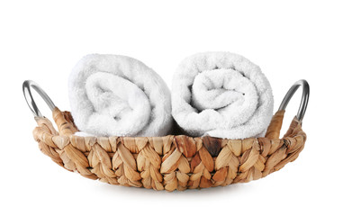 Obraz na płótnie Canvas Wicker basket with soft rolled towels on white background