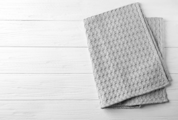 Clean kitchen towel on white wooden table, top view