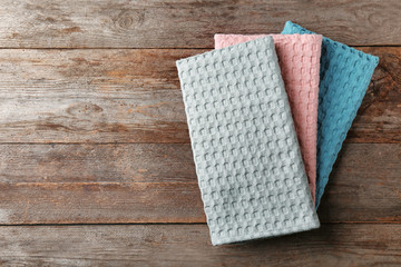 Clean kitchen towels on wooden table, top view