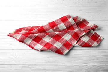 Checkered kitchen towel on white wooden background