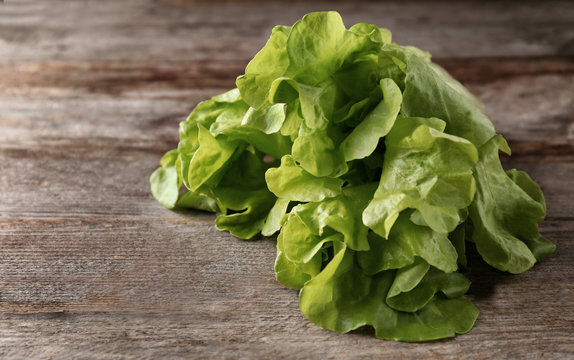 Bunch of fresh green salad on wooden table