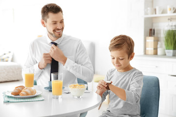 Obraz na płótnie Canvas Father with son having breakfast in kitchen