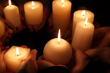 Hands with burning candles, closeup