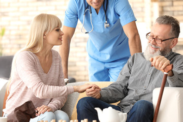 Caregiver with senior man and his daughter at home