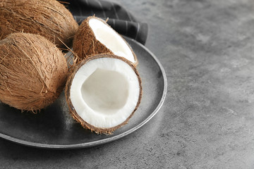 Tray with ripe coconuts on grey background