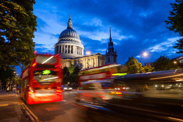 London urban scene with Double Decker bus moves along the St Pauls Cathedral at dusk