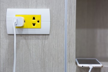 plugging adapter charge the battery with outlet socket plug and hold mobile phone on wall ,electric...