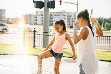 Happy girls playing in public fountain 