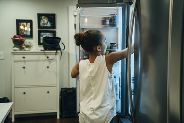 Girl getting food out of fridge