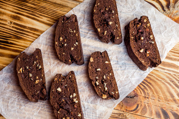 Homemade chocolate biscotti cookies with almonds on parchment paper. Top view