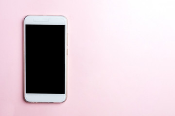 White mobile phone on pink background. Copy space, top view