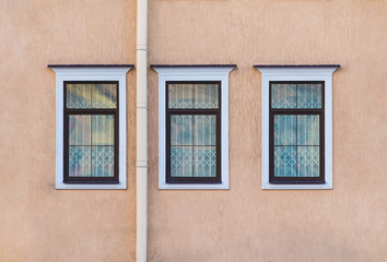 Three windows in a row on the facade of the urban historic building front view, Saint Petersburg, Russia

