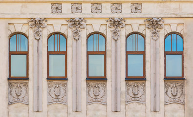 Several windows in a row on the facade of the urban historic building front view, Saint Petersburg, Russia
