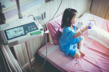 Illness asian child admitted with saline iv drip on hand.