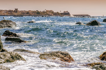 The waves crash on the cliff of Forio in Ischia in sunset