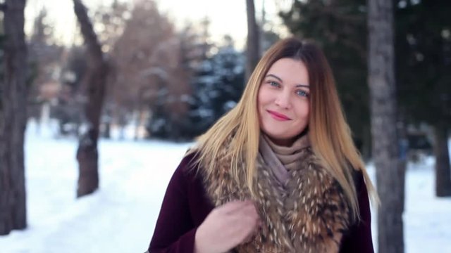 A beautiful girl with a good tidbit runs through the forest and laughs