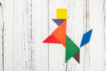 wooden tangram shaped like a dog stands up