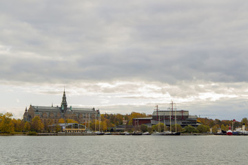 Upmarket historic luxury apartment blocks on the waterfront overlooking a quay with moored tourist boats and ferries, Stockholm, Sweden