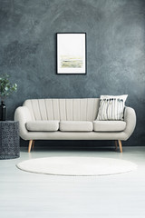 Beige sofa against concrete wall