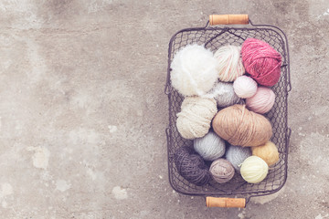 Fototapeta na wymiar coil wool, yarn, metal basket, concrete background