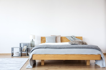 Wooden king-size bed in bedroom - obrazy, fototapety, plakaty