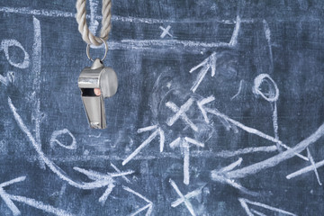 whistle of a soccer coach or referee on black board with strategy drawing