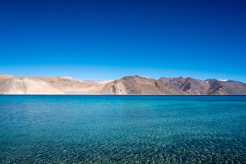 Fototapeta premium Landscape image of Pangong lake with mountains view and blue sky background