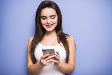 Closeup portrait smiling or laughing young freelancer woman looking at phone seeing good news or photos with nice emotion on her face isolated wall background.