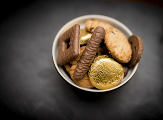 Delicious, yummy and luxurious bowl of luxury biscuits including chocolate chip shortbread cookies, chocolate digestives, chocolate fingers and foiled orange creme biscuits