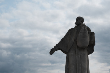 Statue of a monk on the bridge of the castle in Cesky Krumlov, Czech Republic. Silhouette of religious man against a stormy sky.