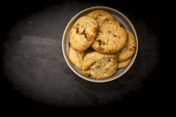 Delicious, yummy and luxurious home baked pistachio nut and chocolate chip shortbread cookies in a round bowl shot from above