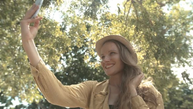 Beautiful woman in hat making selfie photo during her vacation. 