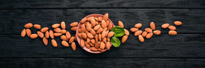 Almond nuts on a dark wooden background. Healthy snacks. Top view. Free space for text.