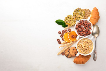 Fitness breakfast, muesli, milk, fruits, nuts and seeds, on a wooden surface. Top view. Free space for text.