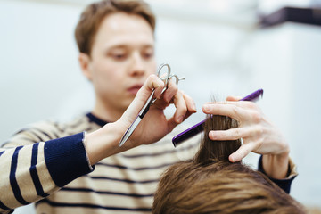 Obraz na płótnie Canvas hairdresser in the beauty salon does a haircut